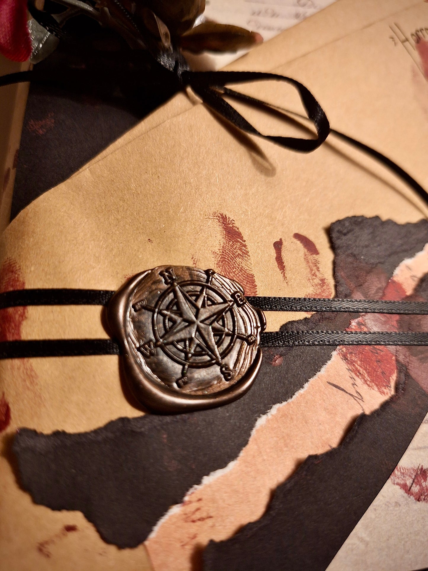Date with a book decorative wrapping: a black wax seal holds a dark ribbon in place. "Bloody fingerprints" cover the wrapping paper.