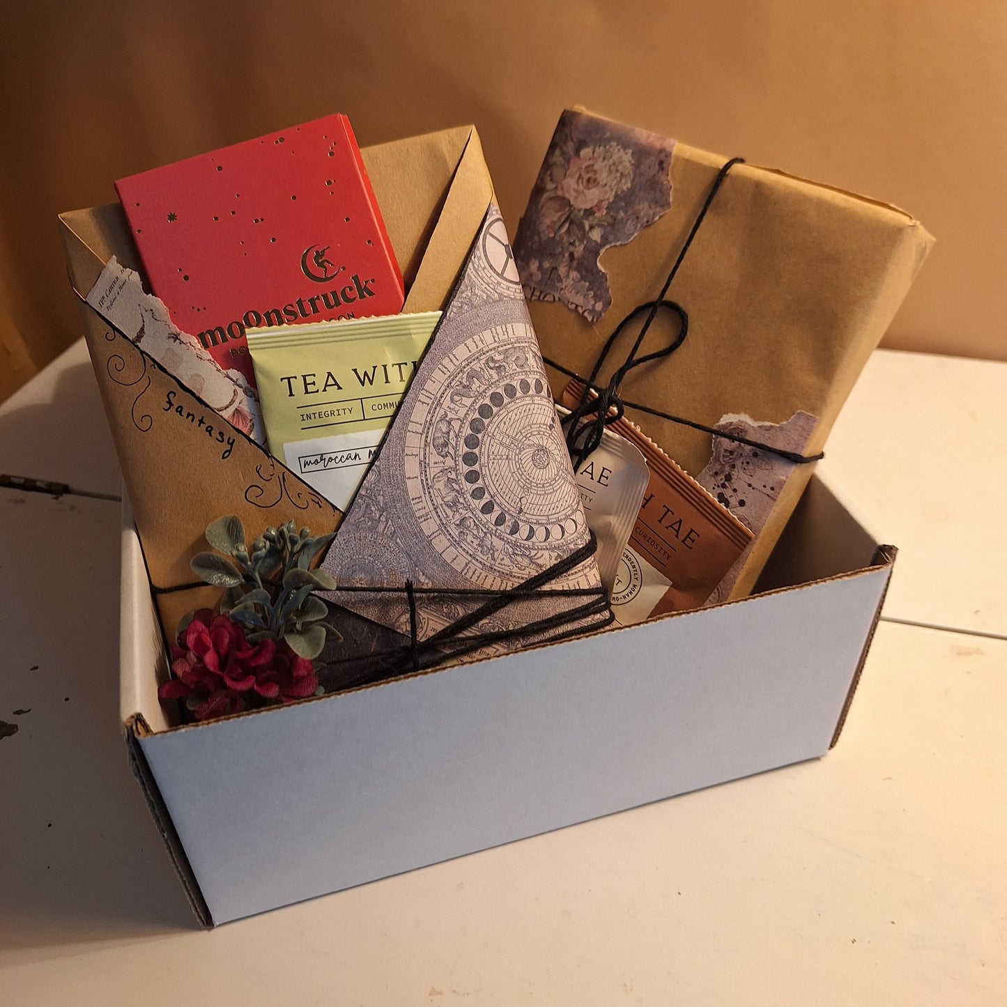 Two uniquely wrapped novels, 1 chocolate bar and three teas in a box