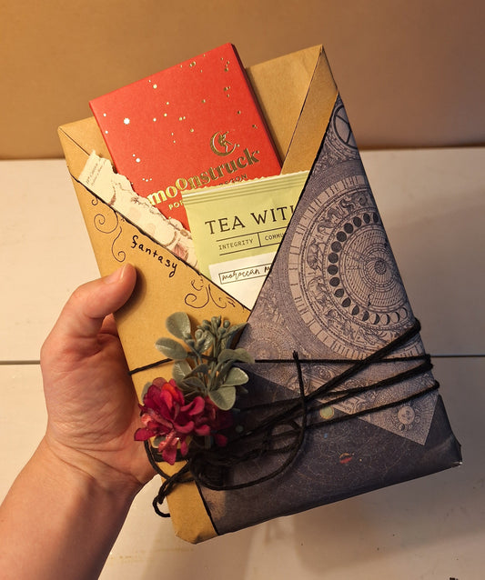 This date with a book package is artistically wrapped in scrapbook paper and includes a book, 1 chocolate bar, and an individually wrapped tea.